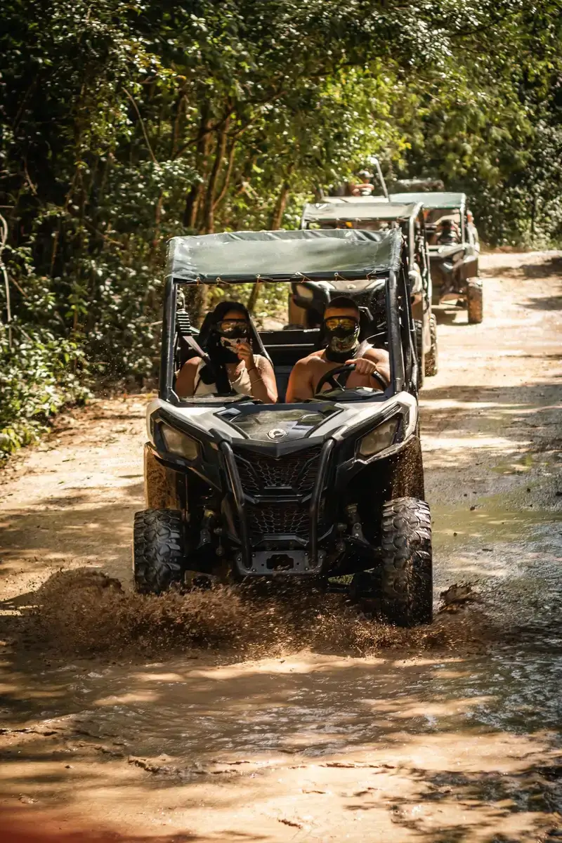 Off-road buggy parked beside a jungle cenote on a Maya village tour from Playa del Carmen, Mexico